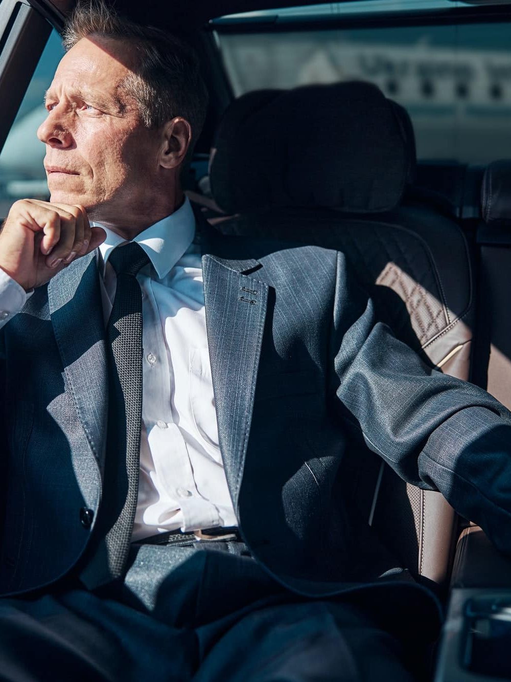 Businessman leaving airport in comfortable car with driver